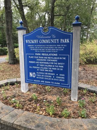 Royal blue sign with the words Wyckoff Community Park listing rules and regulations for park use