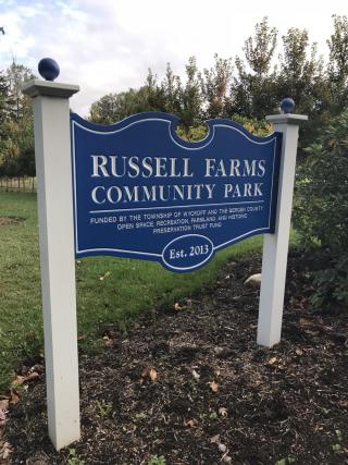 Royal Blue sign with the words Russell Farms Community Park